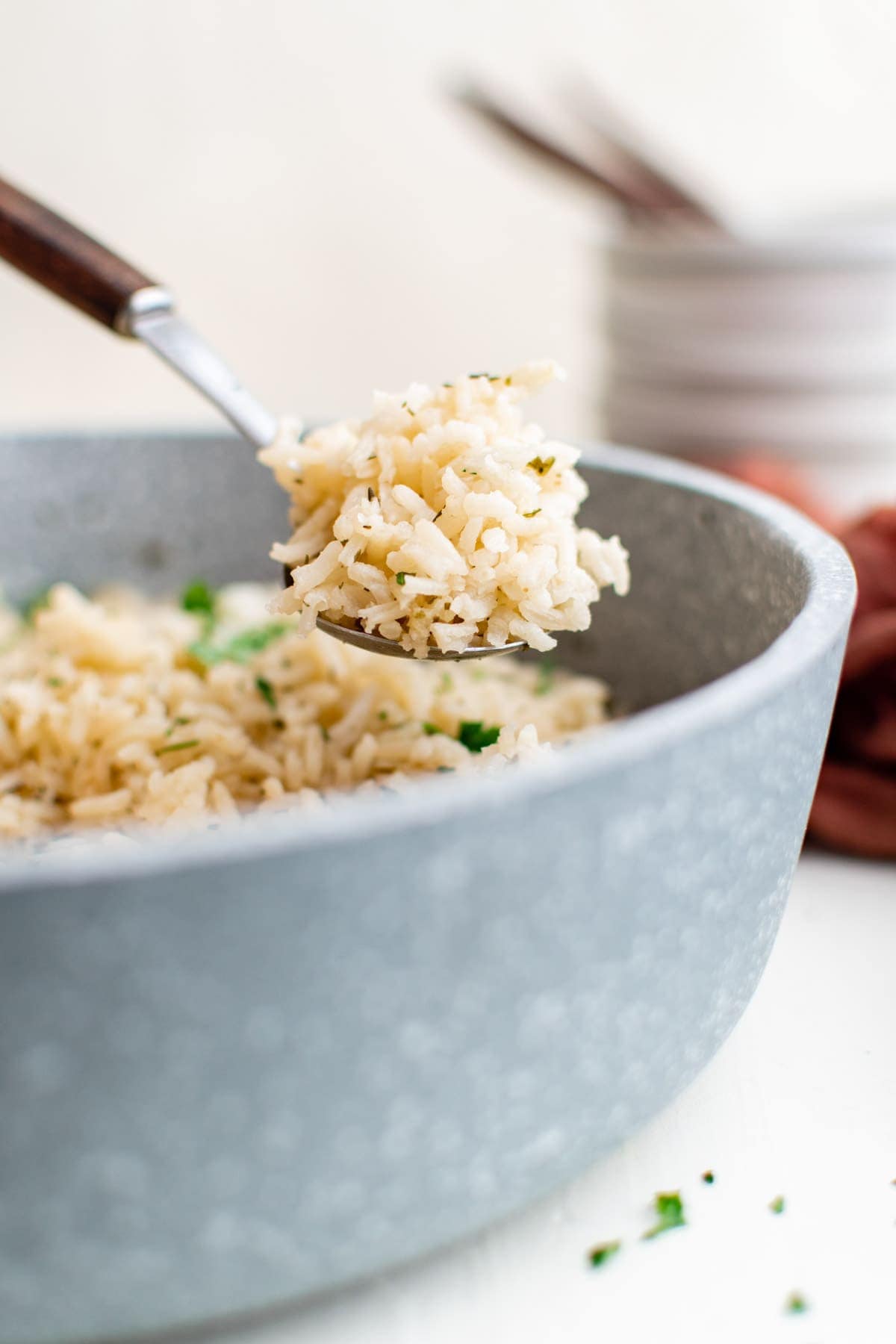 gray skillet with rice and herbs, spoon with wooden handle