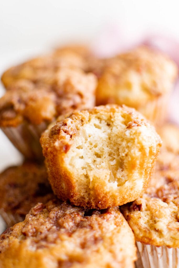 stack of rhubarb muffins, the top one with a bite taken