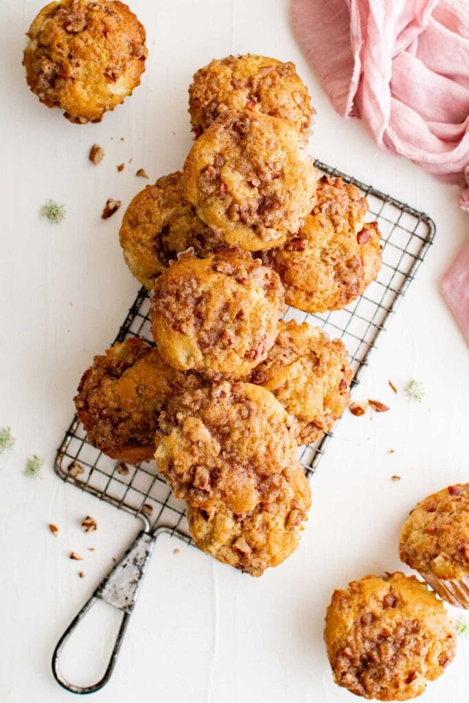 overhead pic of muffins with rhubarb on a small wire rack, a pink napkin