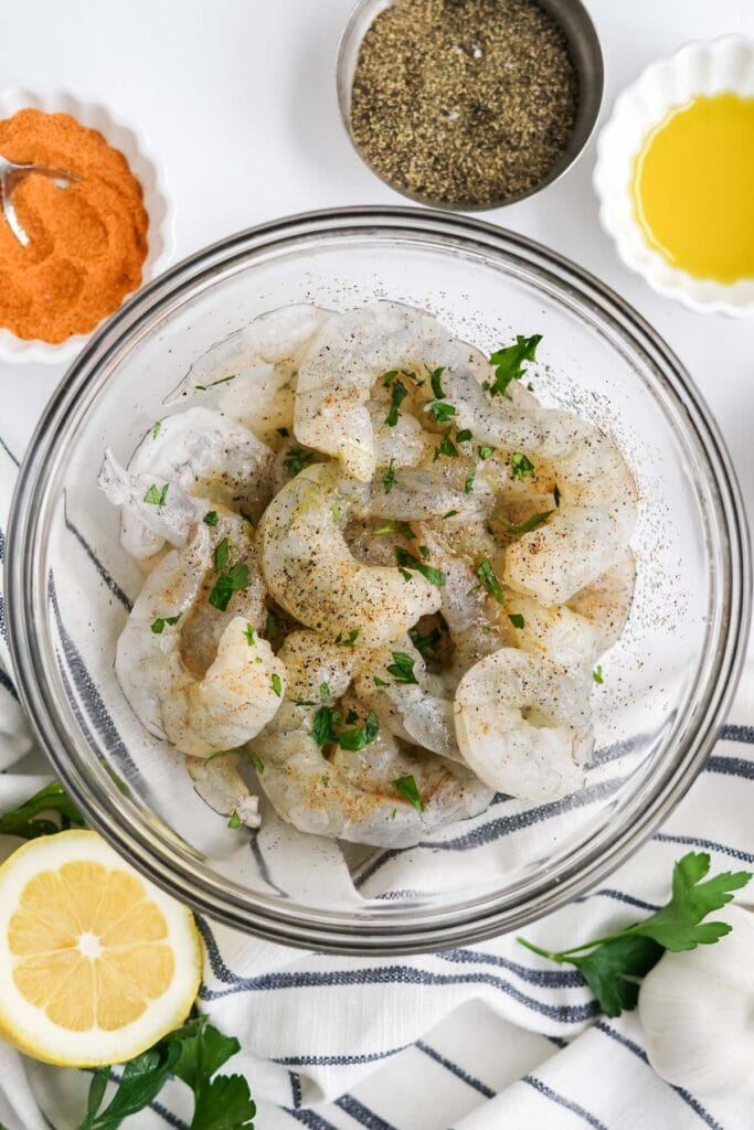 raw shrimp in a glass bowl with seasoning