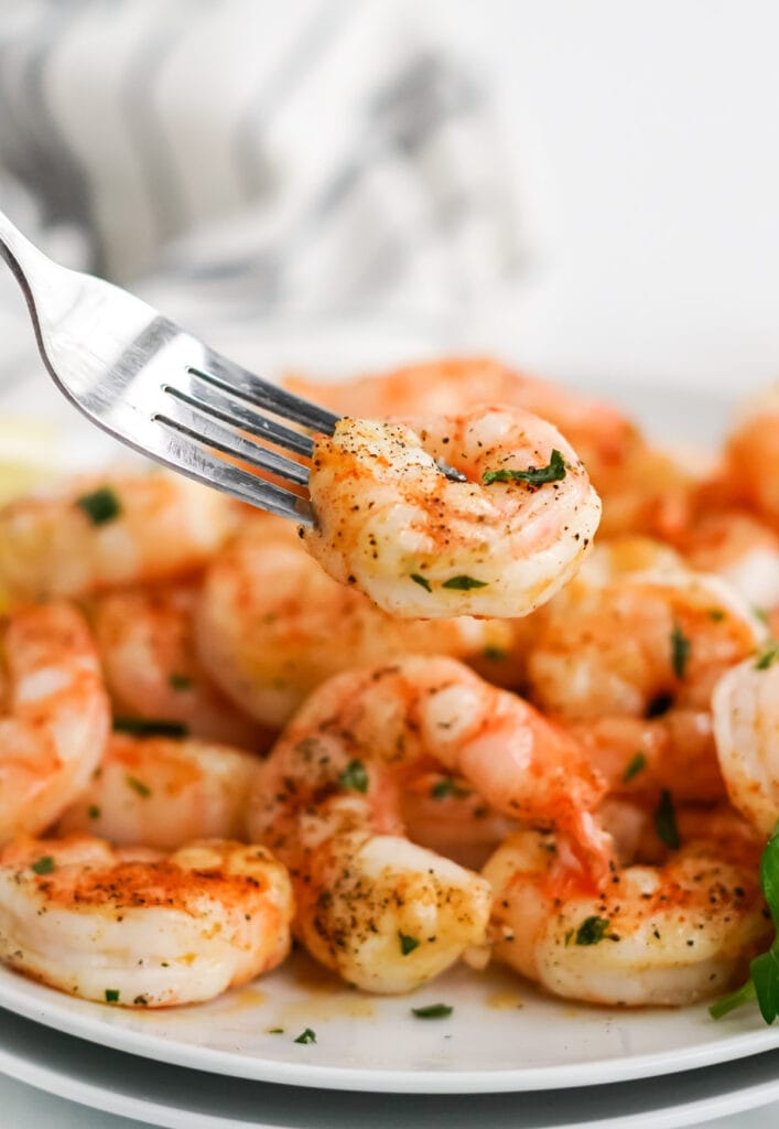 cooked air fryer shrimp on a white plate, a fork