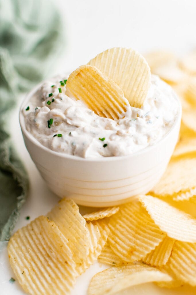 french onion dip in a white bowl with potato chips
