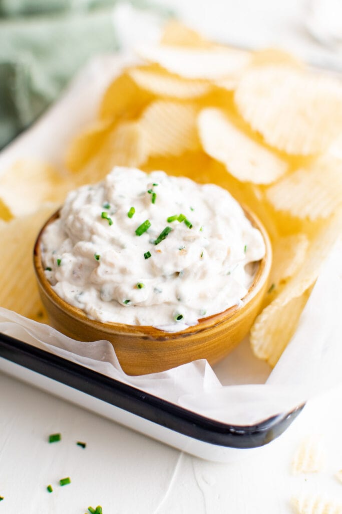 tray with parchment paper, chips, onion dip, wood bowl