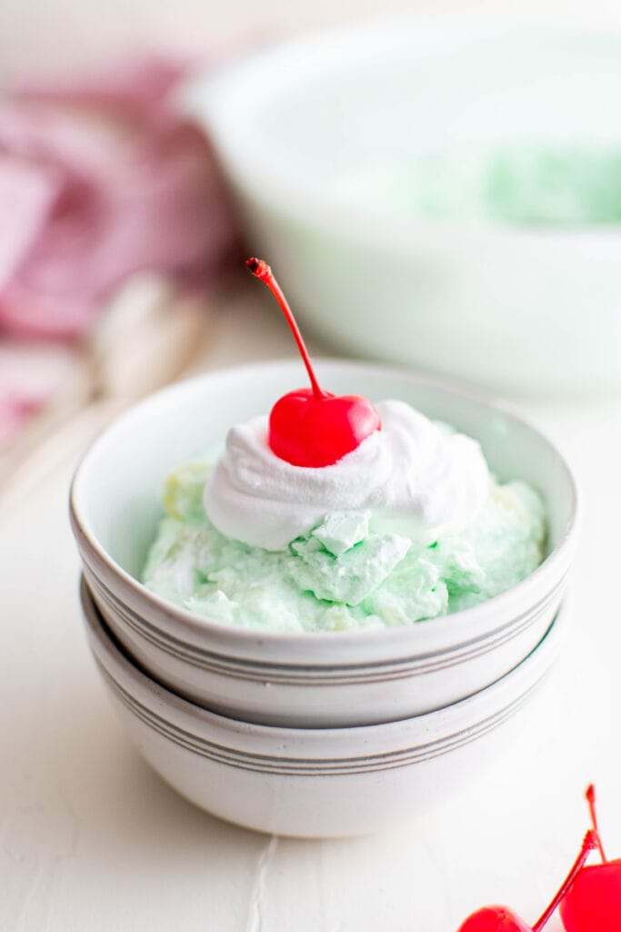 blue and white striped dish with jello salad and a cherry