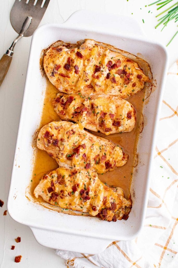 white casserole dish with chicken with bacon and cheese