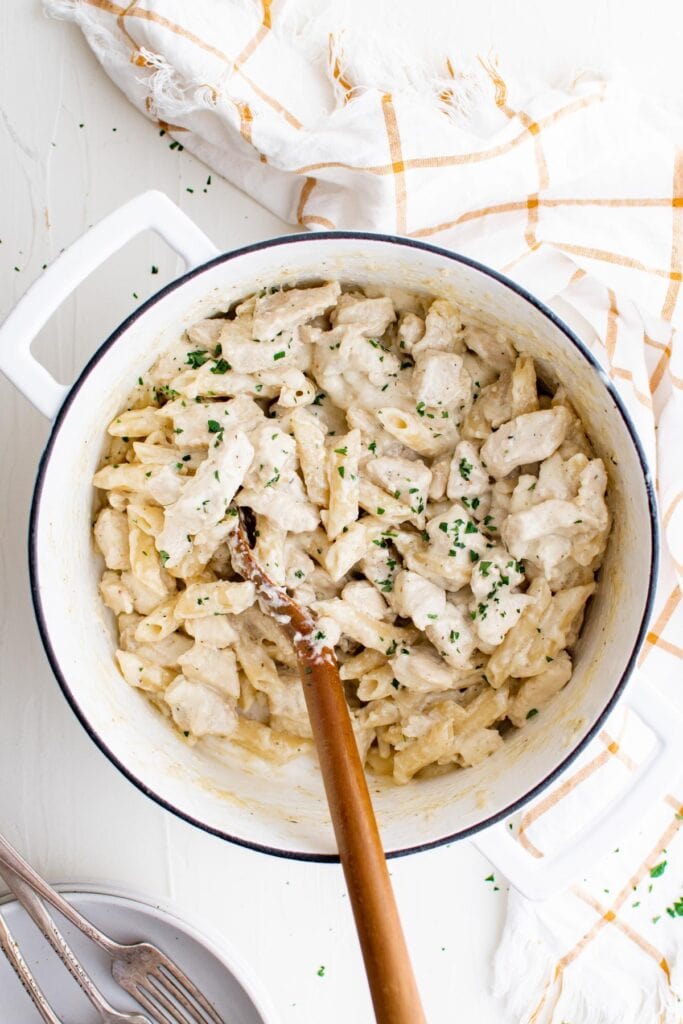 white pot with pasta, alfredo sauce and chicken