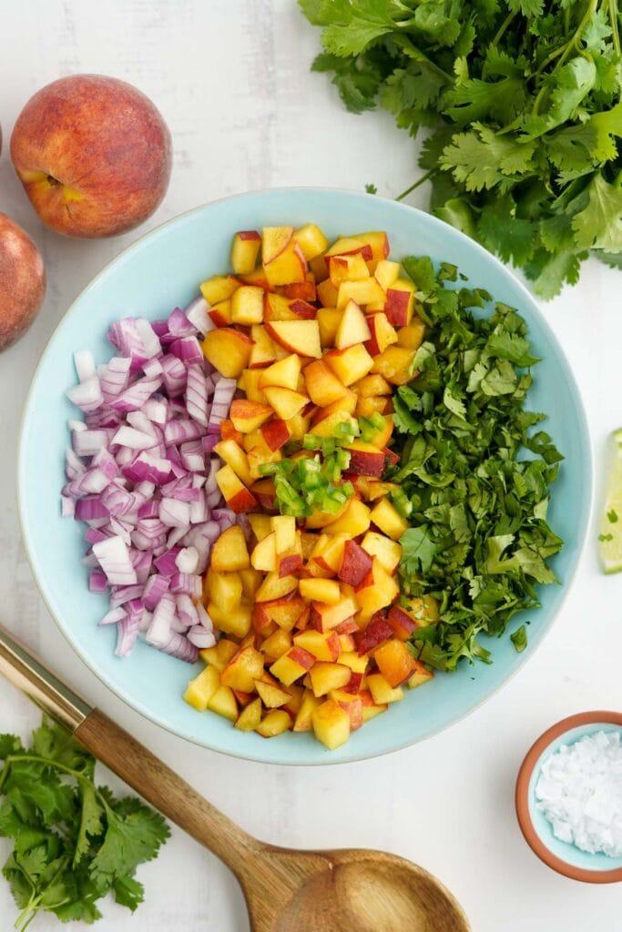 chopped peaches, onion, cilantro in a bowl