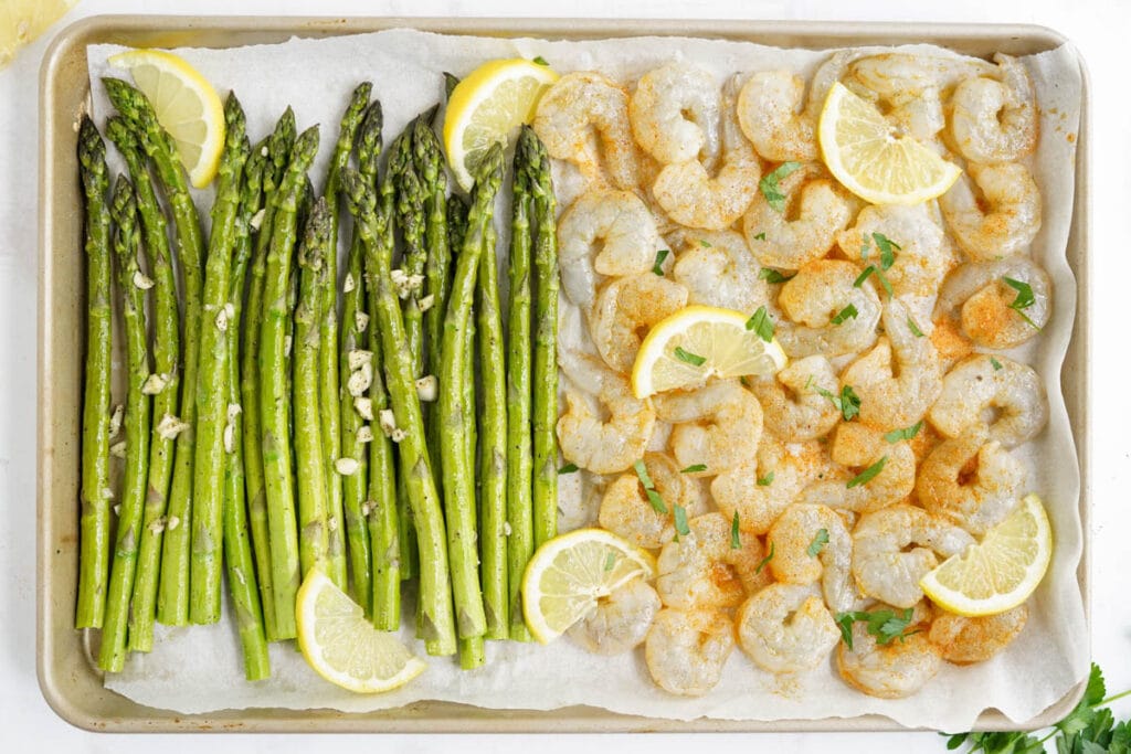 asparagus and raw seasoned shrimp on a sheet pan