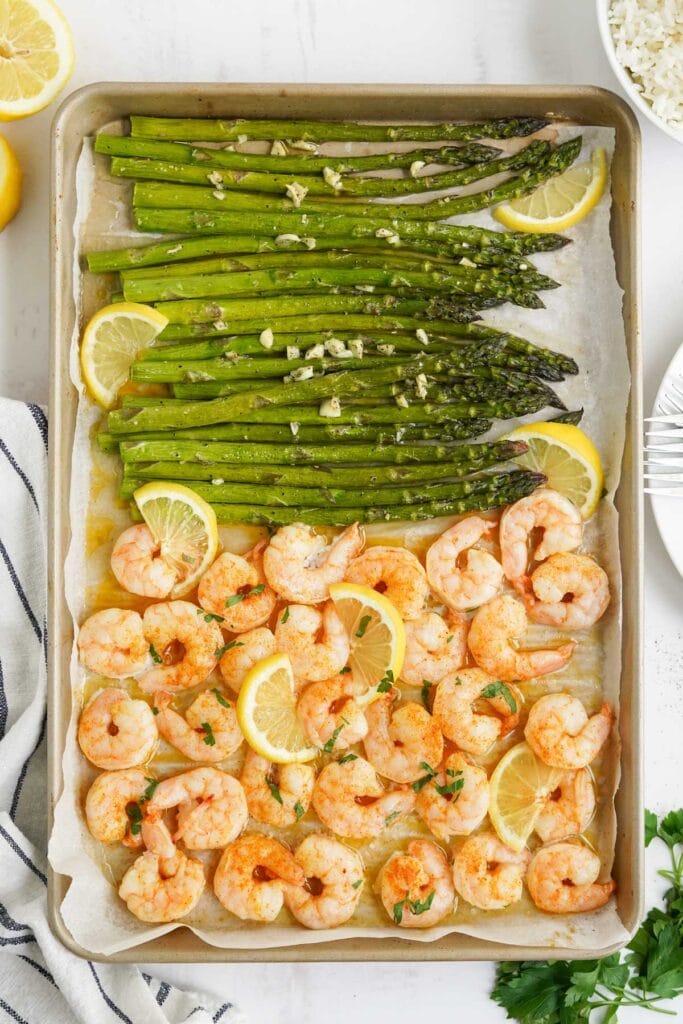 asparagus and shrimp on a sheet pan with lemon slices