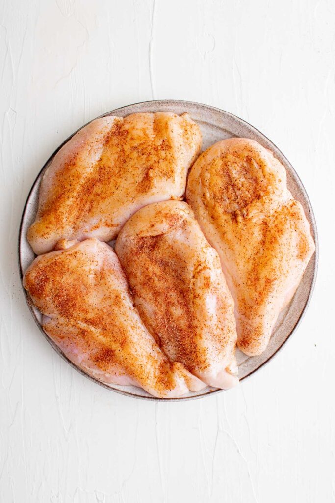 chicken breasts with seasoning on a plate
