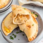 Baked chicken empanadas, one split in half.