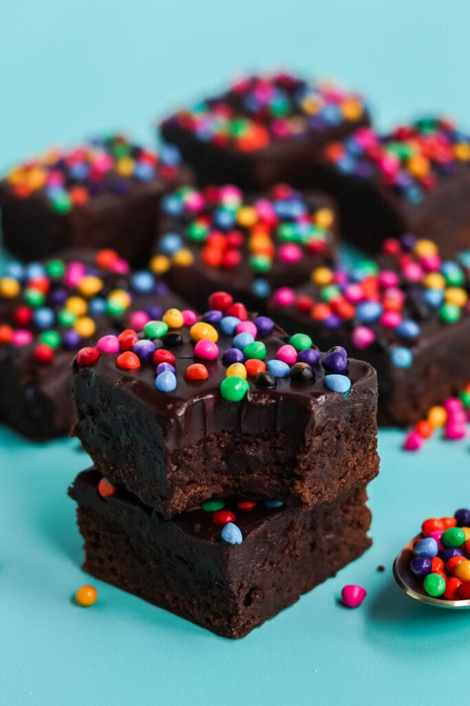brownies stacked with a bite taken out, rainbow candy sprinkles