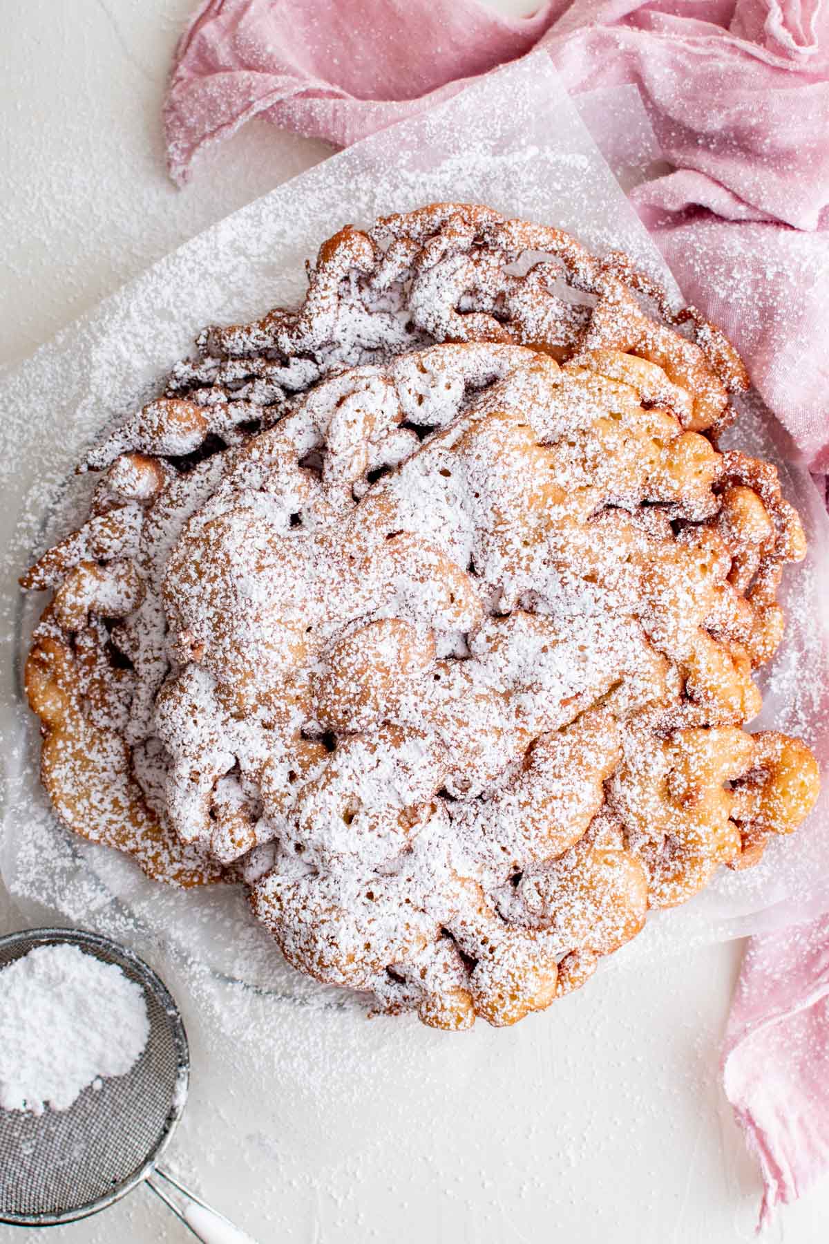 funnel cake with powdered sugar and a pink towel