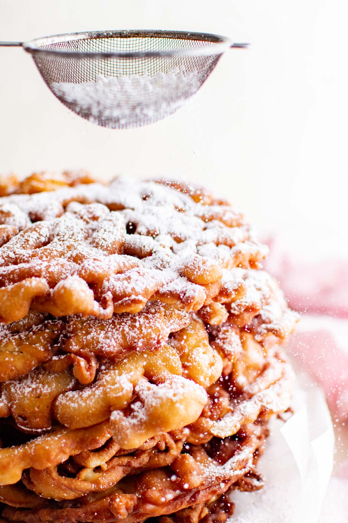 stack of funnel cakes with powdered sugar