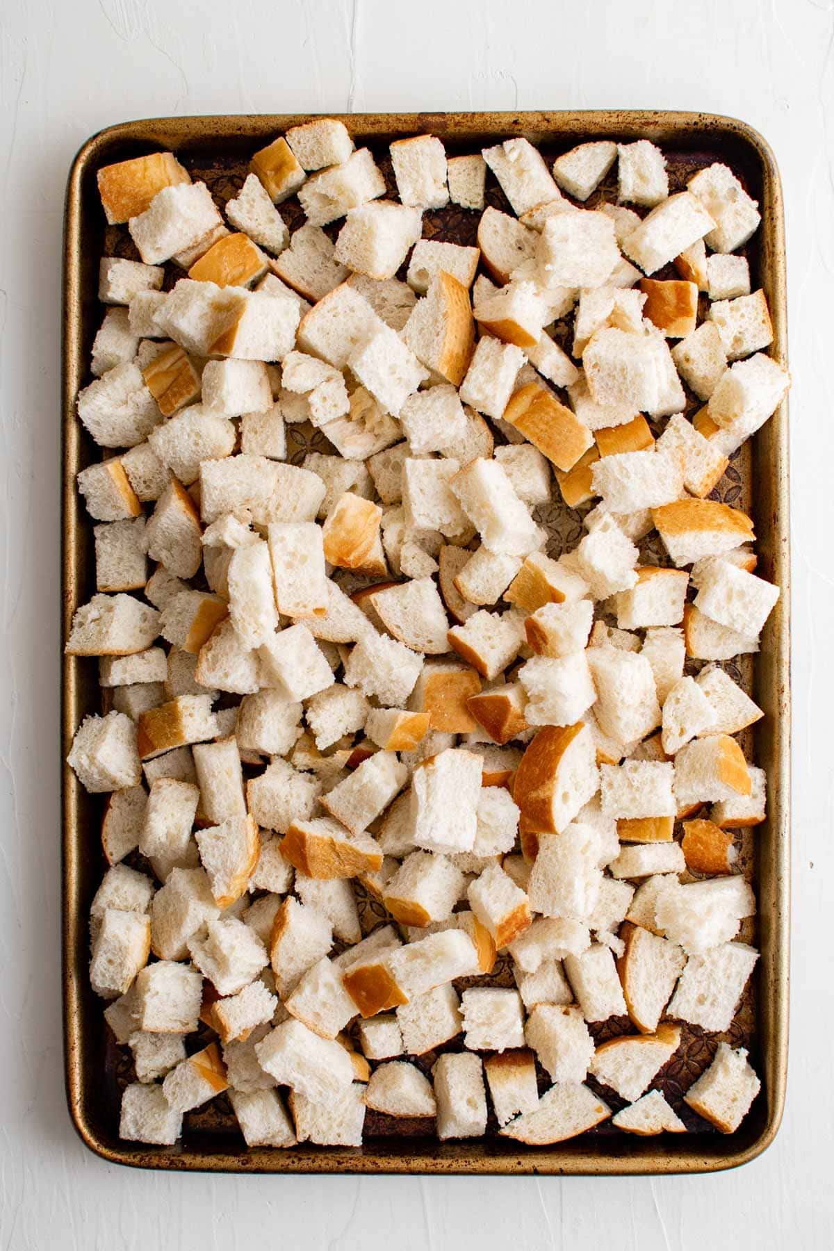 cubes of french bread on a baking sheet.