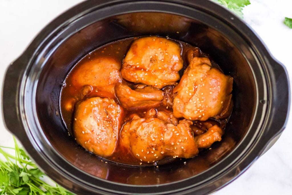 slow cooker with chicken thighs and sauce