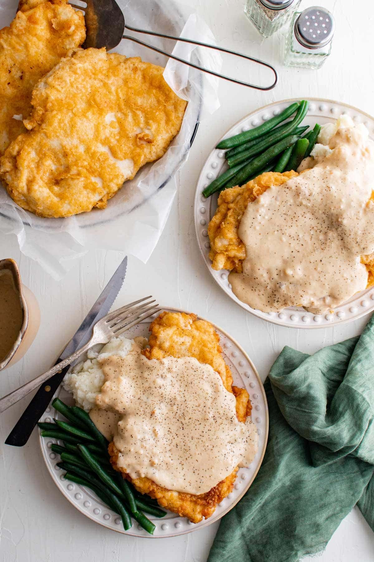 plates with chicken fried chicken, gravy and green beans