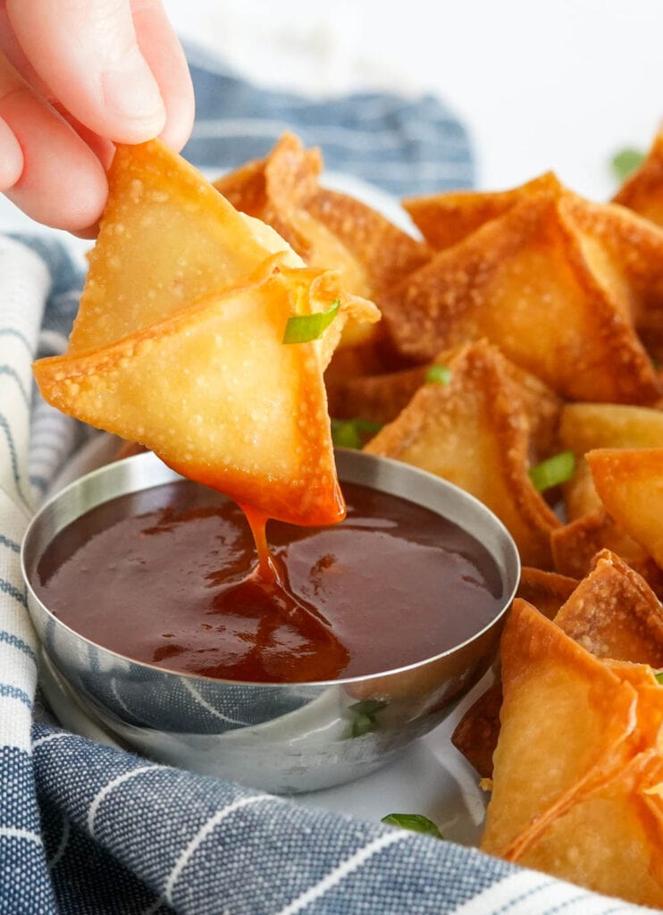 crab rangoon dipped into a red chile sauce