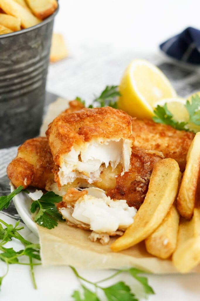 fish and chips in a basket, showing the inside of the flaky white fish