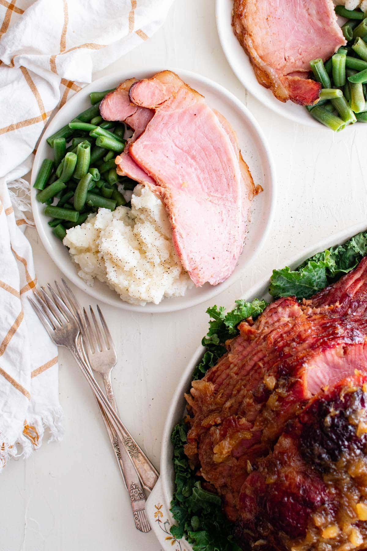 ham, mashed potatoes and green beans on a plate next to a whole ham