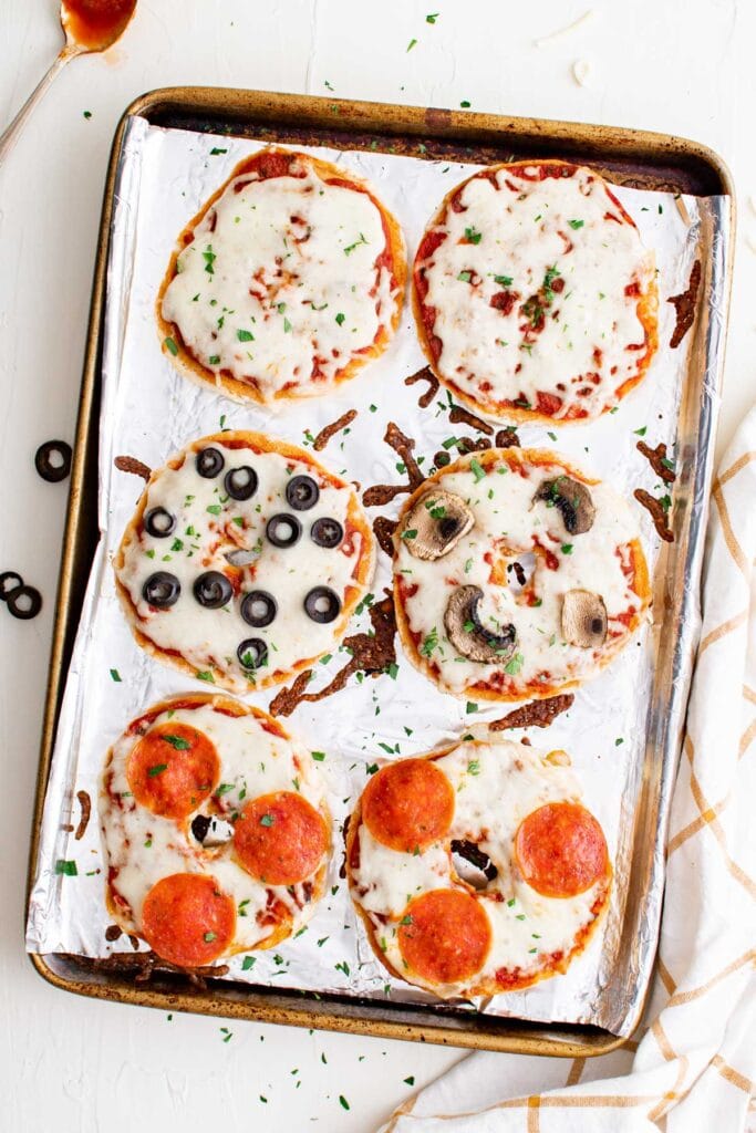 pizza bagels on a baking sheet