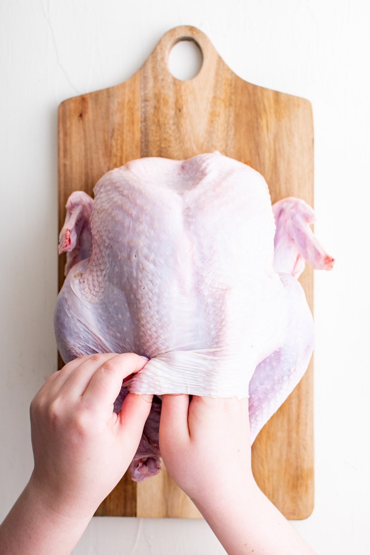 hand slid under skin on a turkey breast