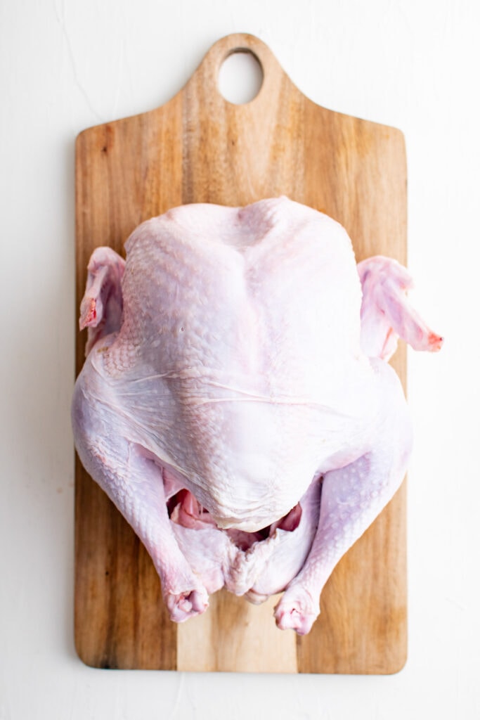 raw whole turkey on a cutting board