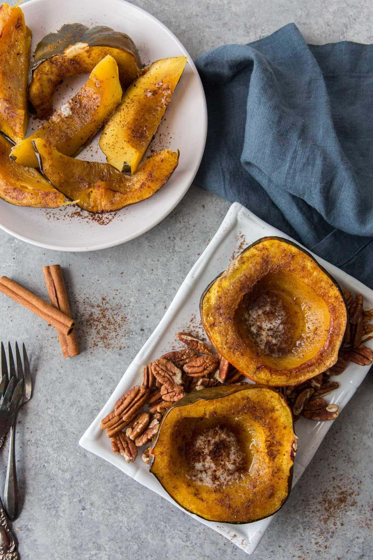 Baked acorn squash halves topped with butter, syrup and cinnamon