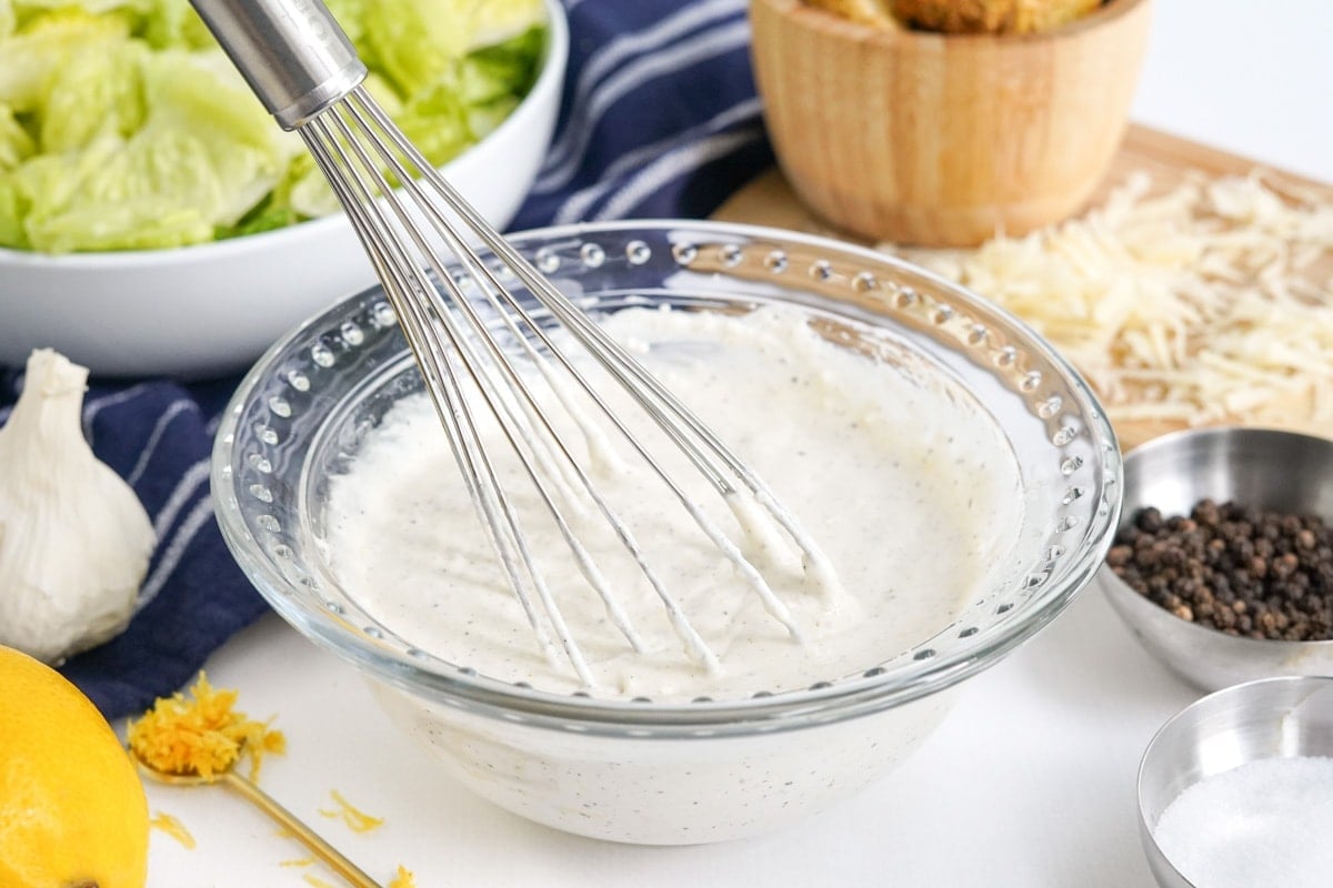 whisked caesar dressing in clear glass bowl