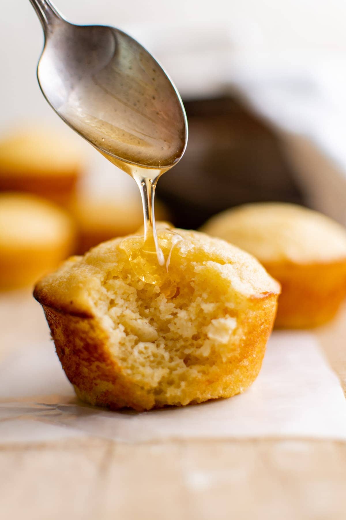 corn muffin with spoon and honey drizzle