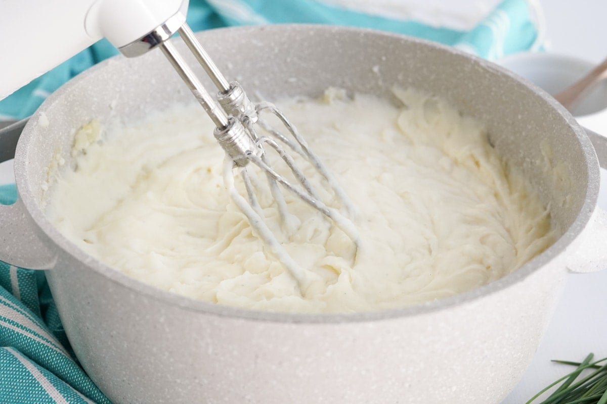 whipped cream cheese potatoes in a pot with a hand mixer