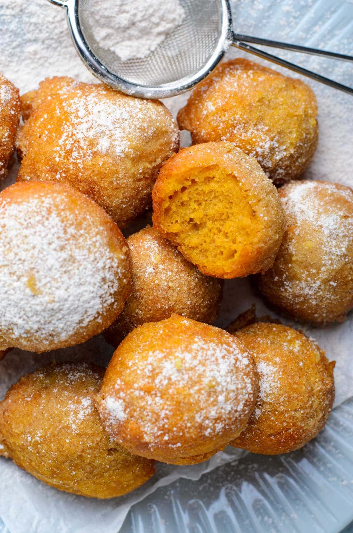 fried pumpkin fritters with a bite taken out of one of them.