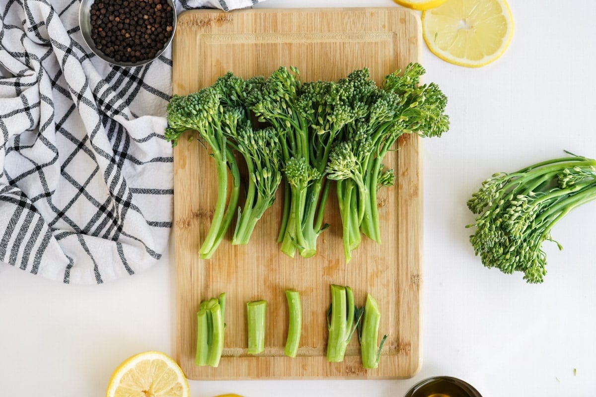 broccolini on a butting board with ends trimmed off