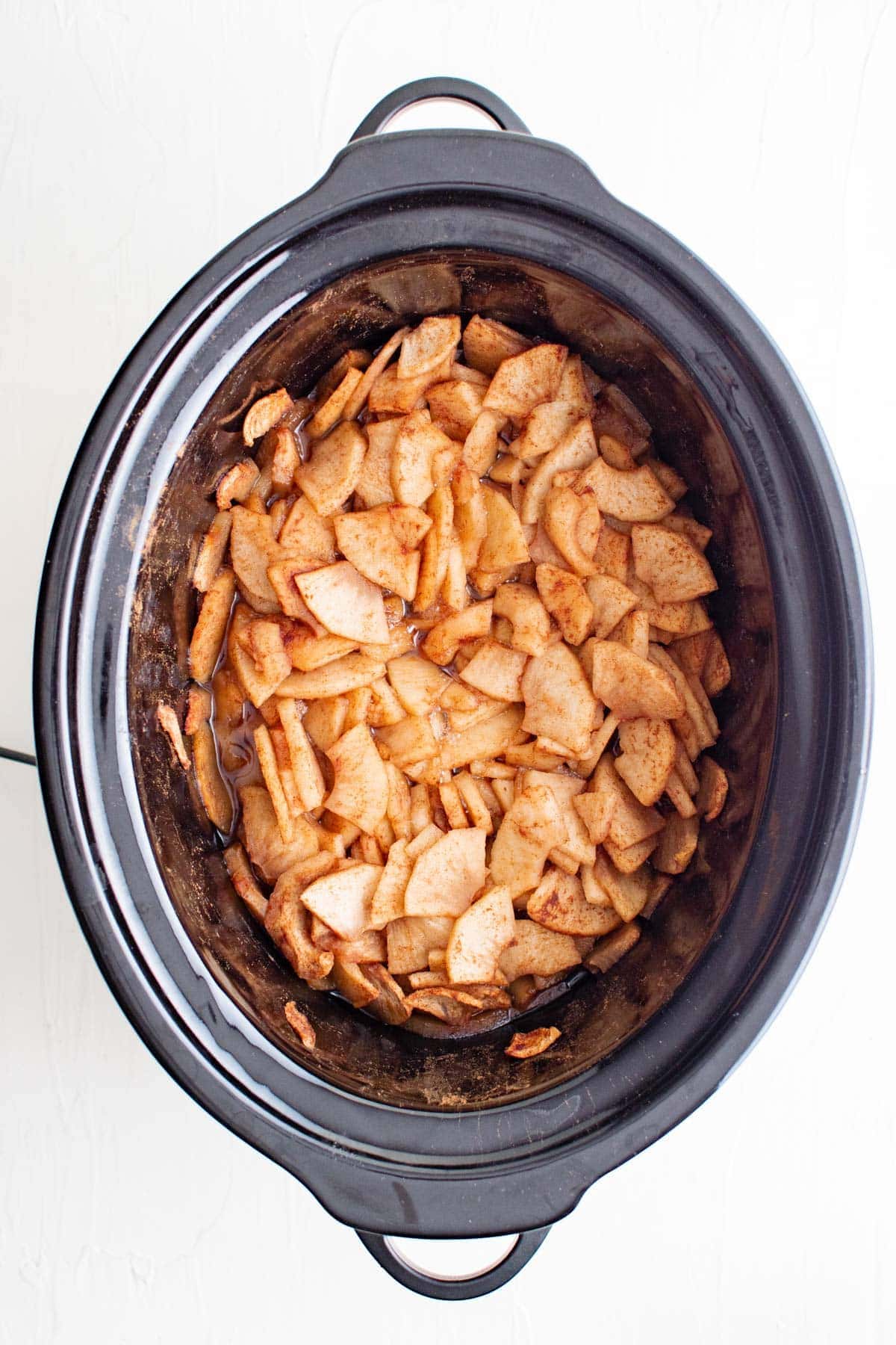 apples coated with cinnamon and sugar in a slow cooker
