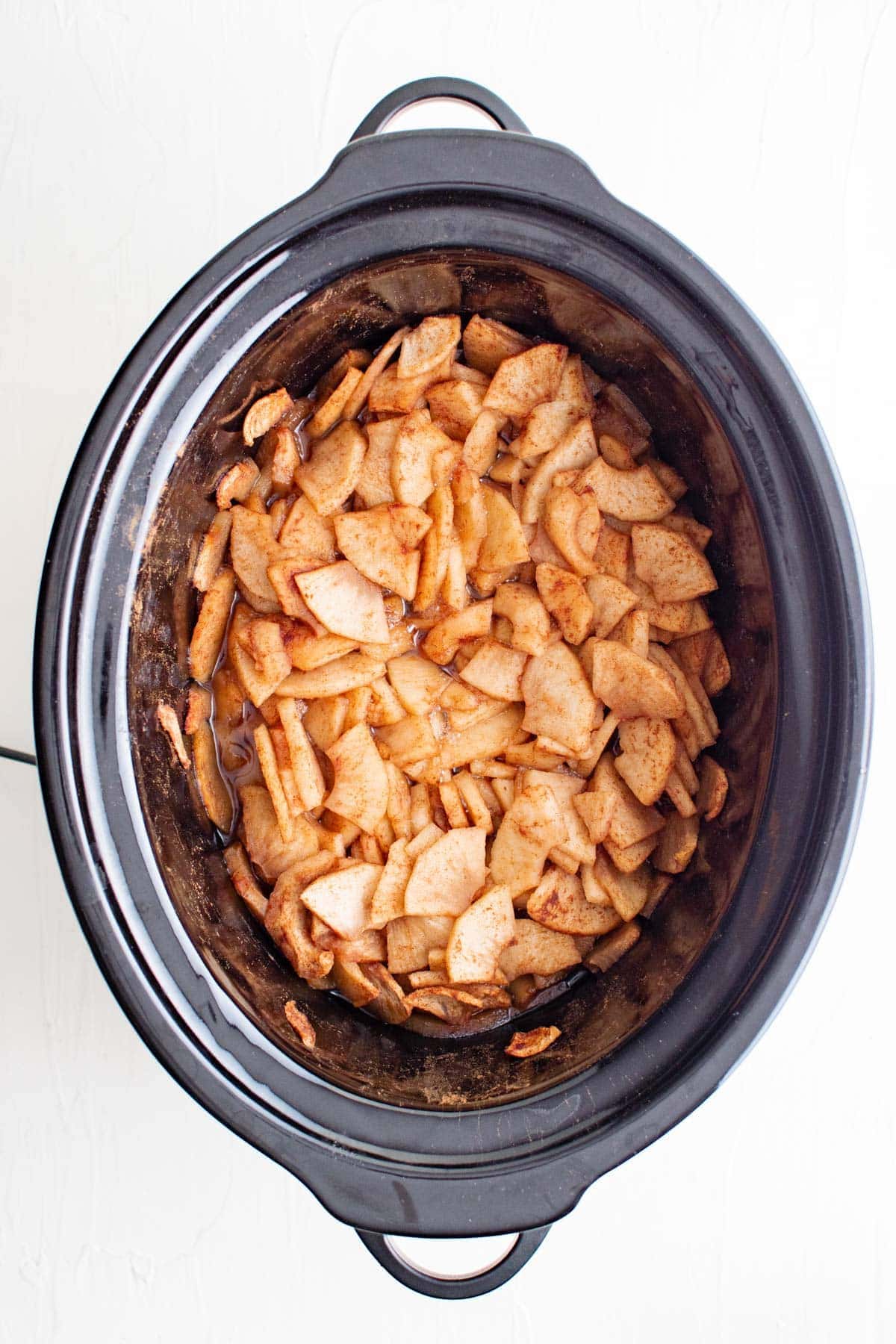 apples coated with cinnamon and sugar in a slow cooker