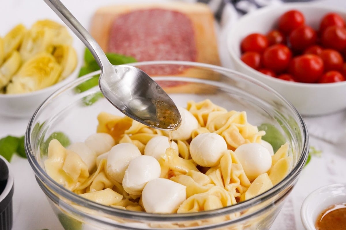 tortellini and mozzarella balls in a clear glass bowl