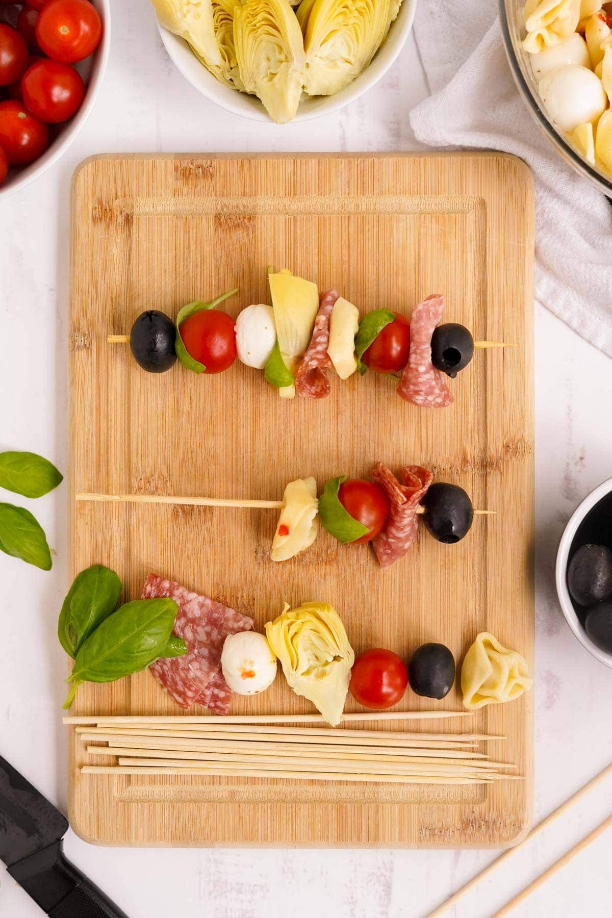 showing the steps for making antipasto skewers