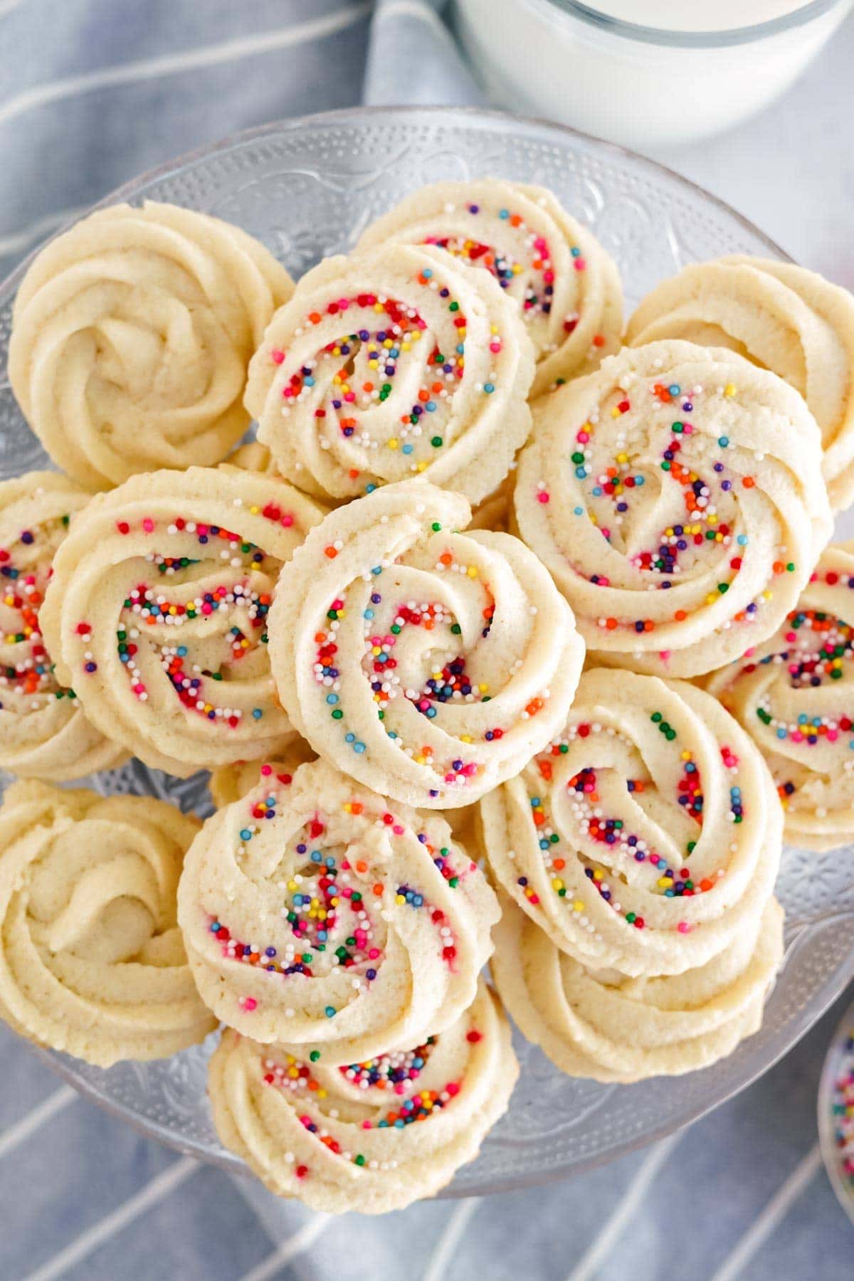 but cookies with multi colored sprinkles stacked on a tray