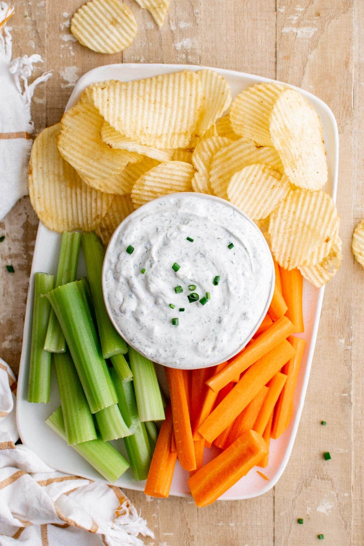 platter of potato chips, carrots, celery and sour cream dip