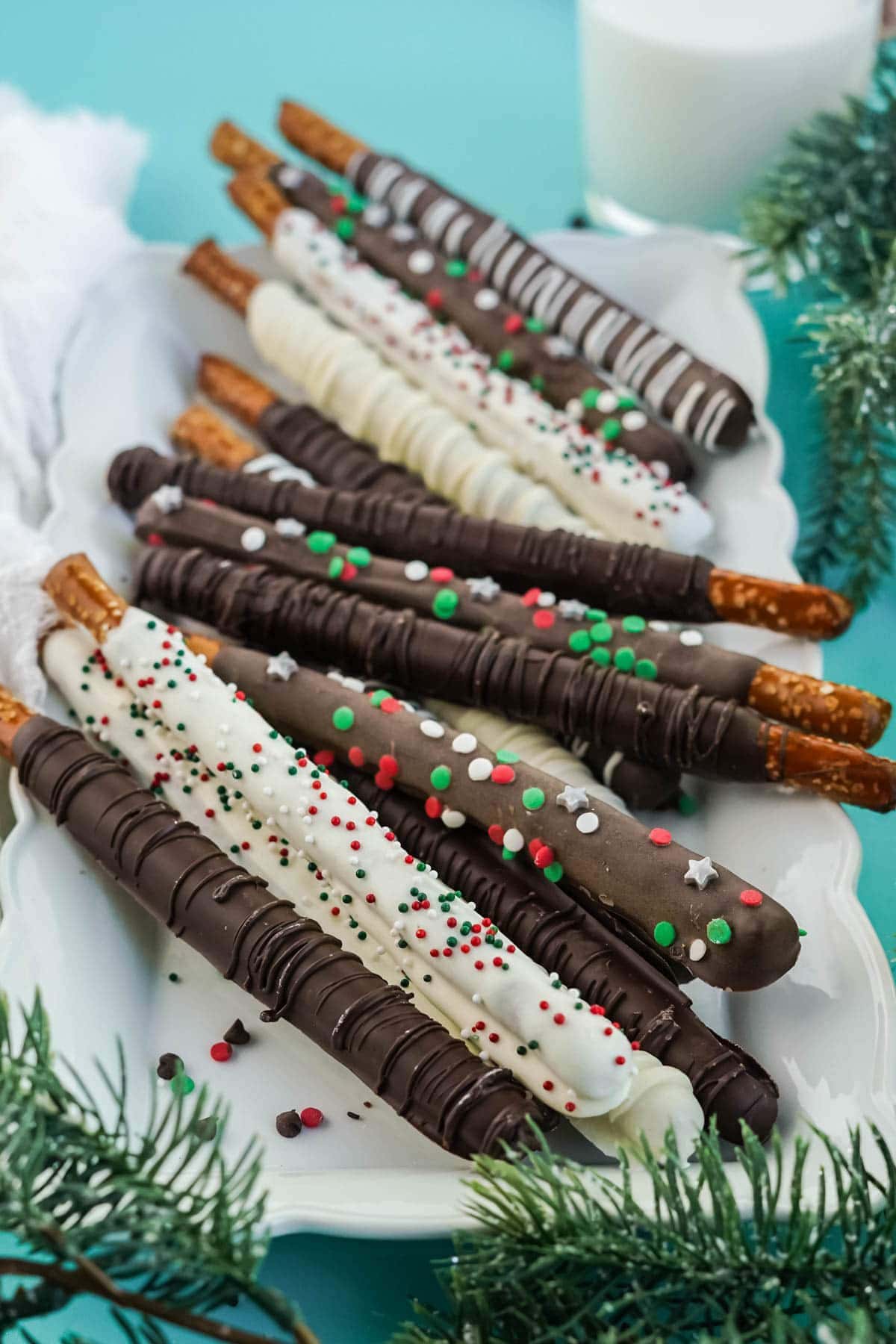 chocolate dipped pretzels with sprinkles on white platter