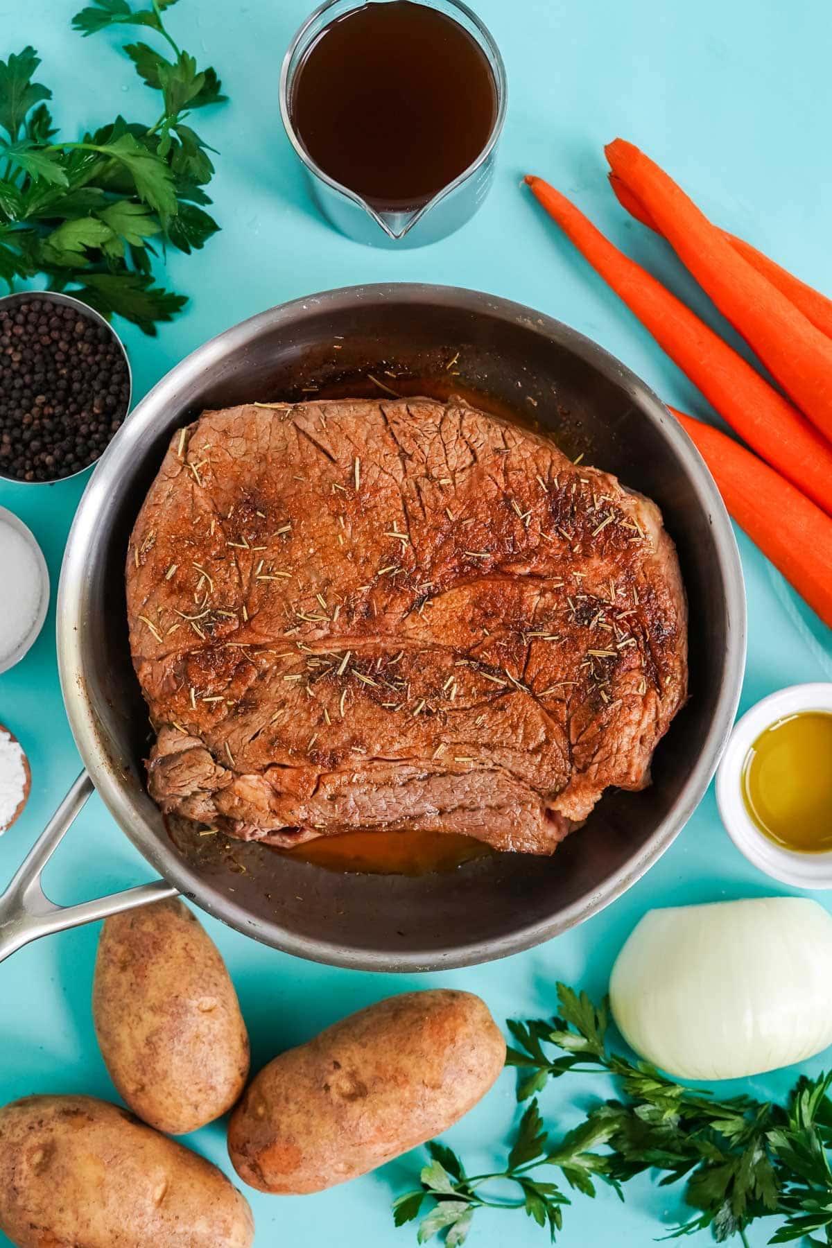 chuck roast in a skillet with seasoning