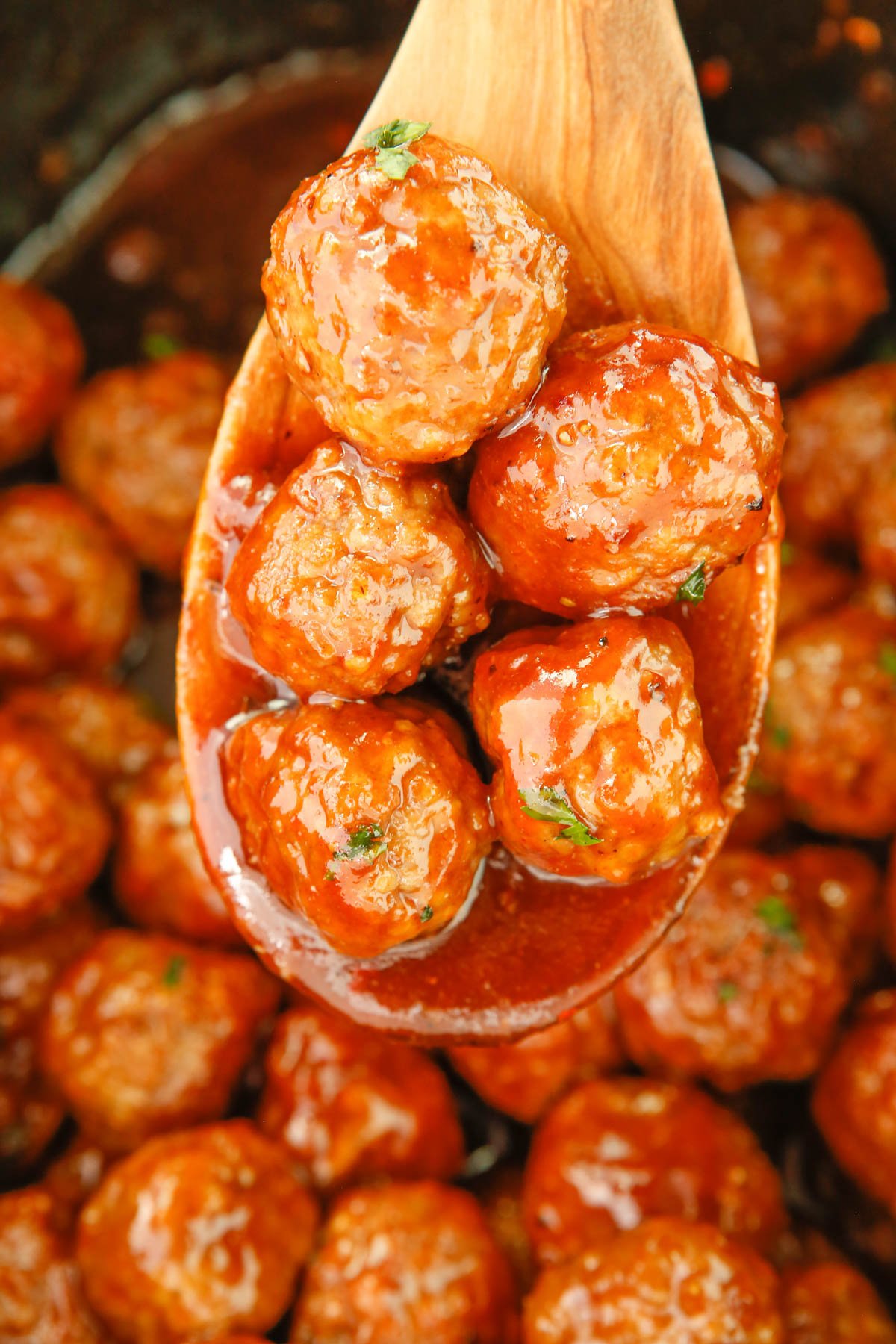 meatballs on a wooden spoon in a crockpot