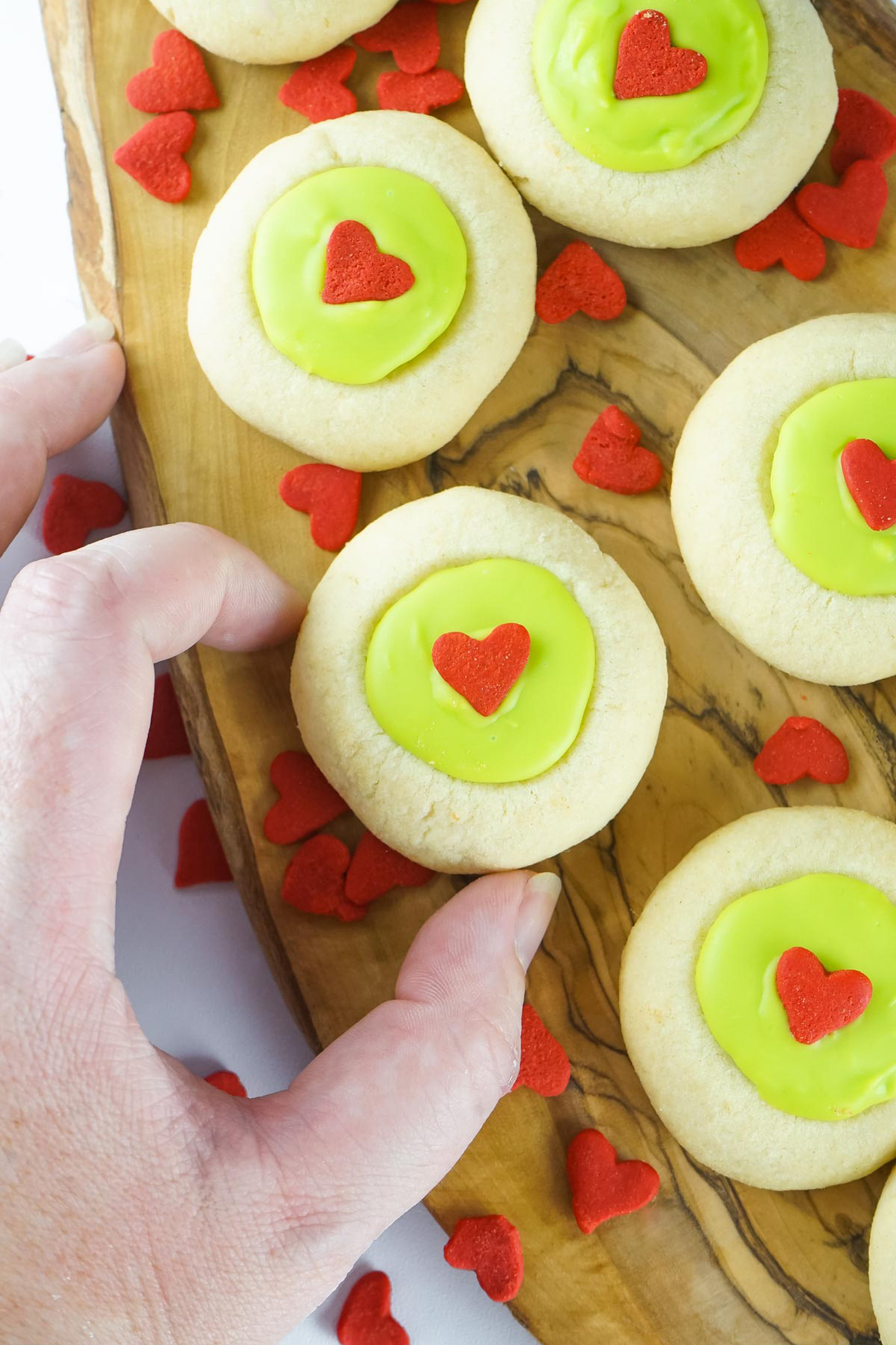 grinch thumbprint cookies, a hand