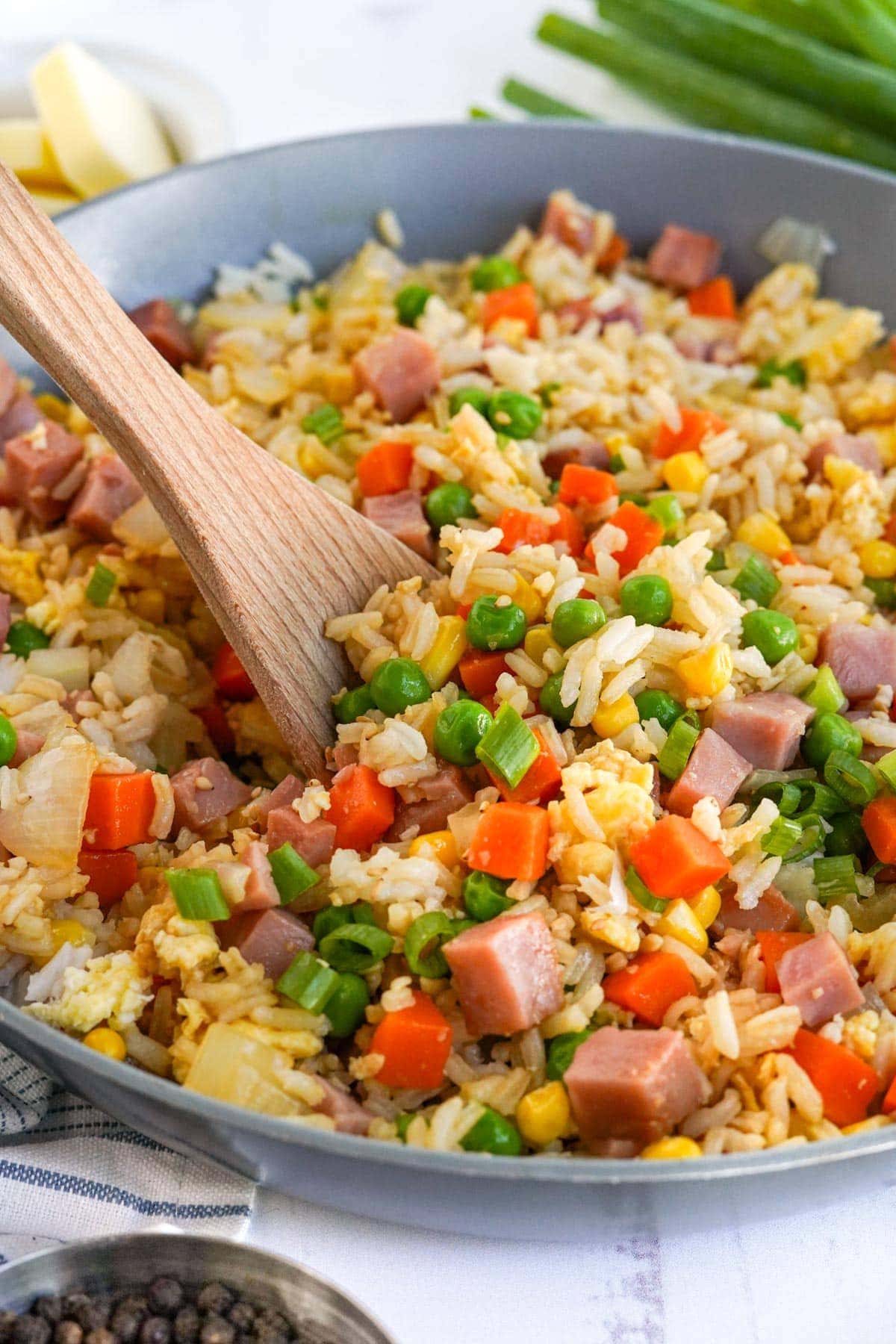 ham fried rice in a skillet with wooden spoon