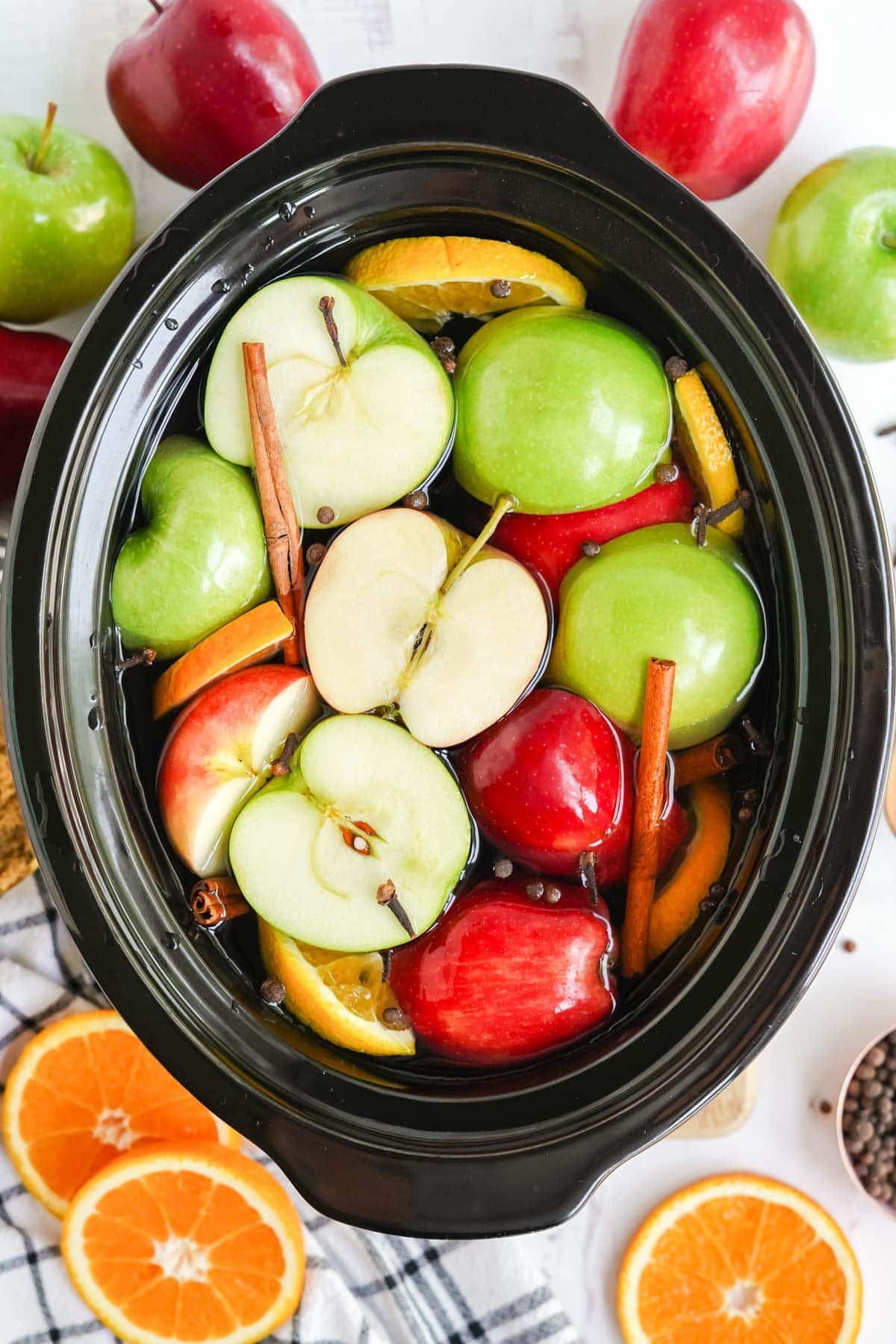 apple halves and cinnamon sticks in a slow cooker
