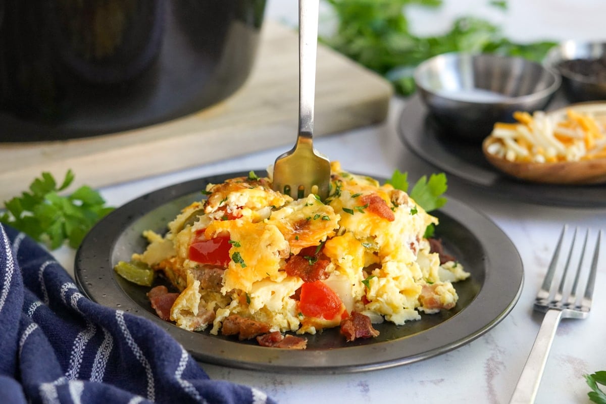 breakfast casserole on a black plate with a fork