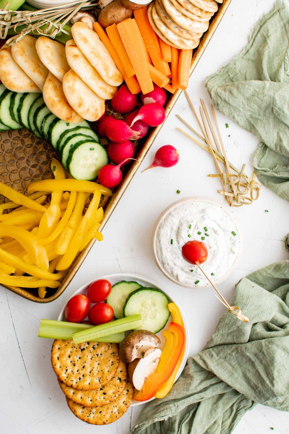 tray of vegetables, crackers and dip, small plate of veggies, green napkin