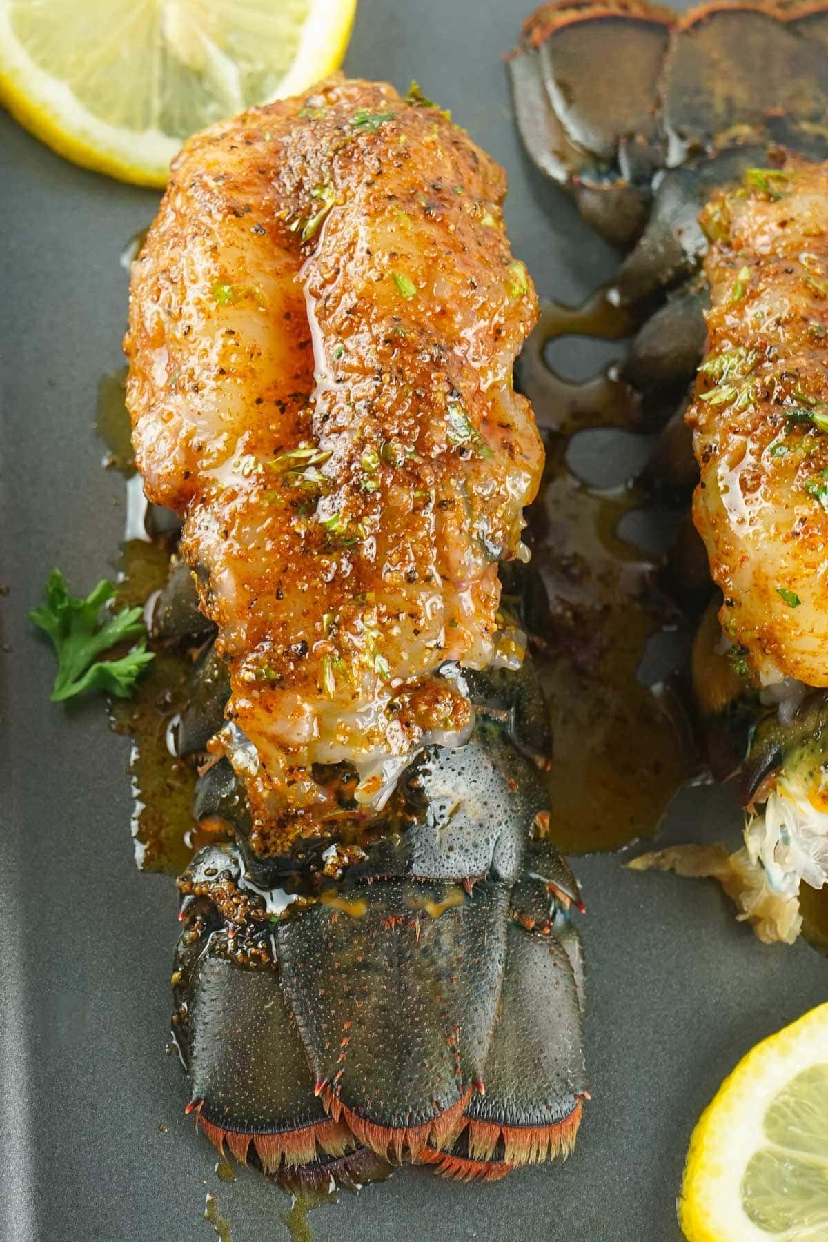 raw lobster tail with seasoning and melted butter