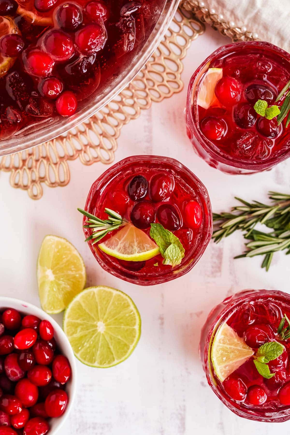 glasses of champagne punch with rosemary, lime and mint garnish