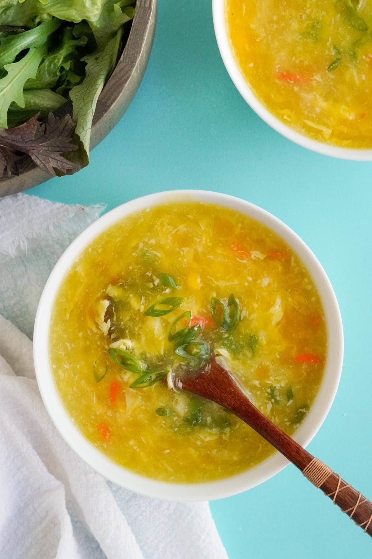 bowl of egg drop soup with a wood spoon